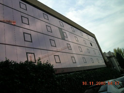 Edificio de Aena en Arturo Soria con fachada de vidrio reflectante, tomado desde un ángulo inclinado